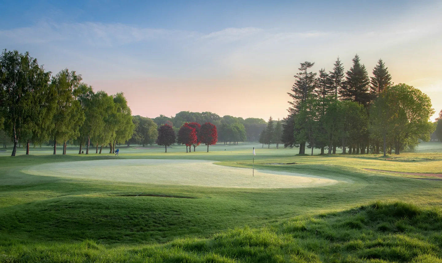 Golf hole in the morning with mist on the fairway at a golf course in Surrey
