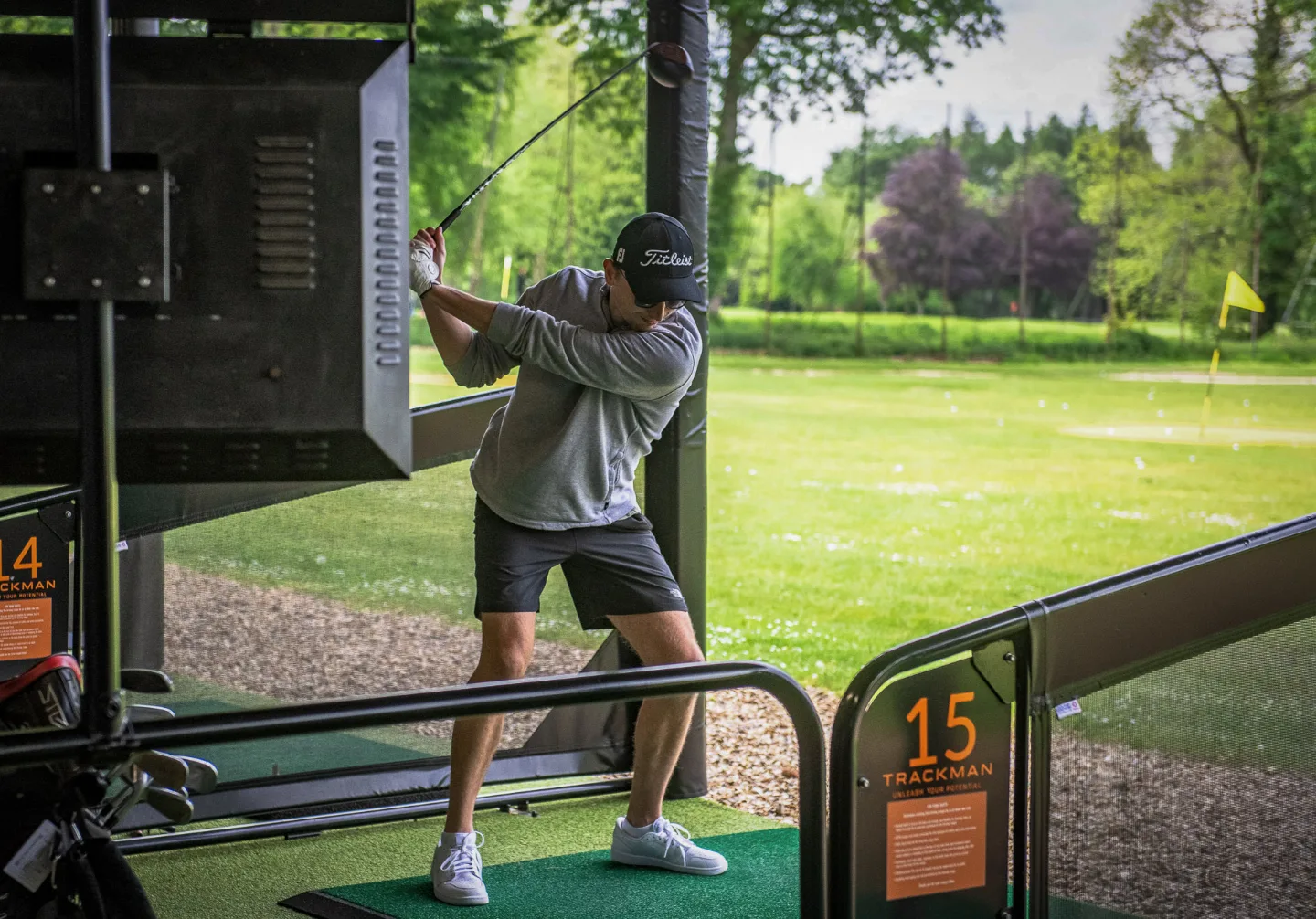 Golfer hitting a ball on a driving range in Surrey
