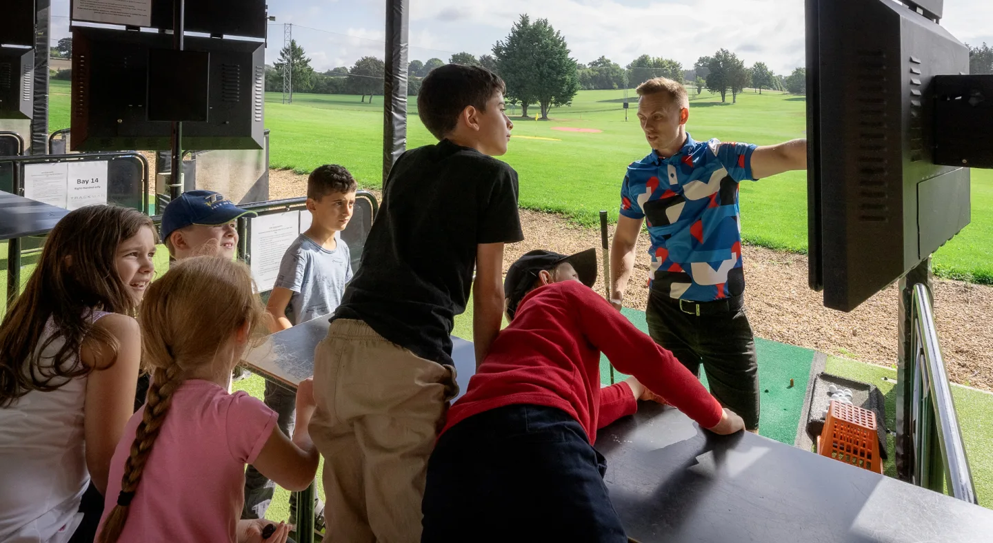 junior group golf camp at a driving range in surrey