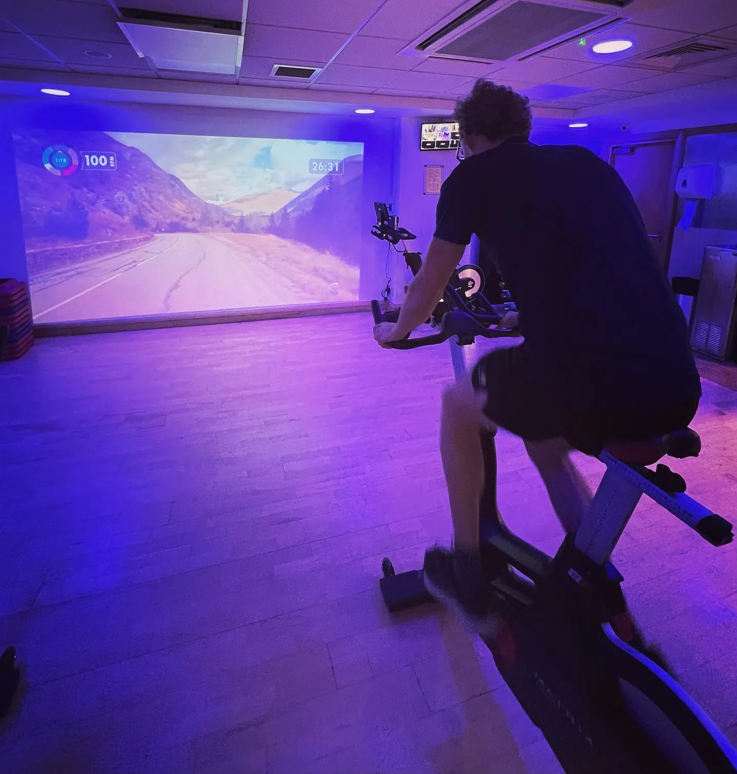 man cycling at the gym during a spin class in woking
