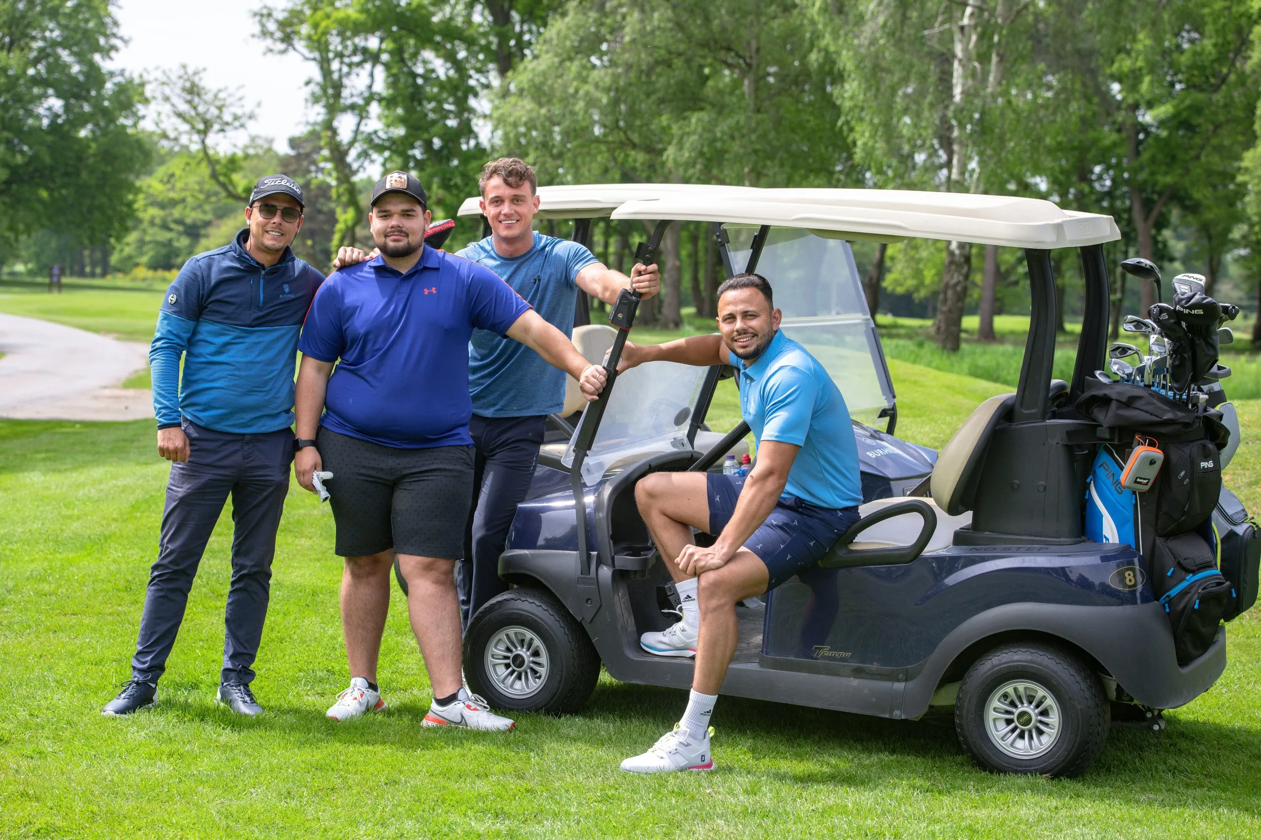 Group of golfers sitting on a golf buggy at a golf course near woking
