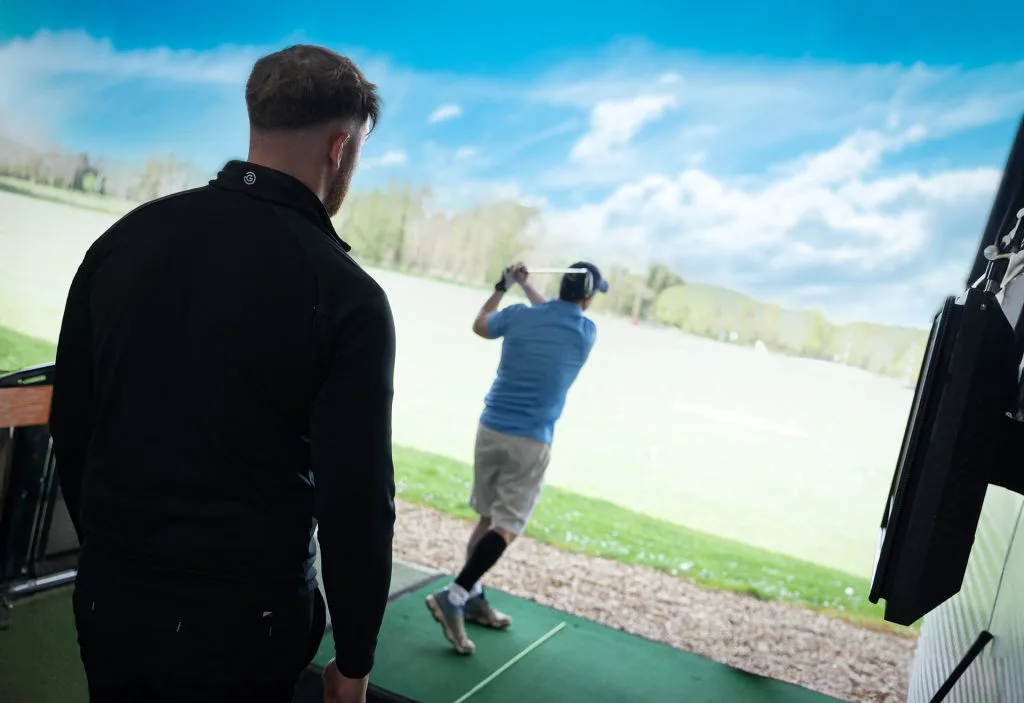 Golf lesson in Surrey with a golf coach watching a player swing at the driving range