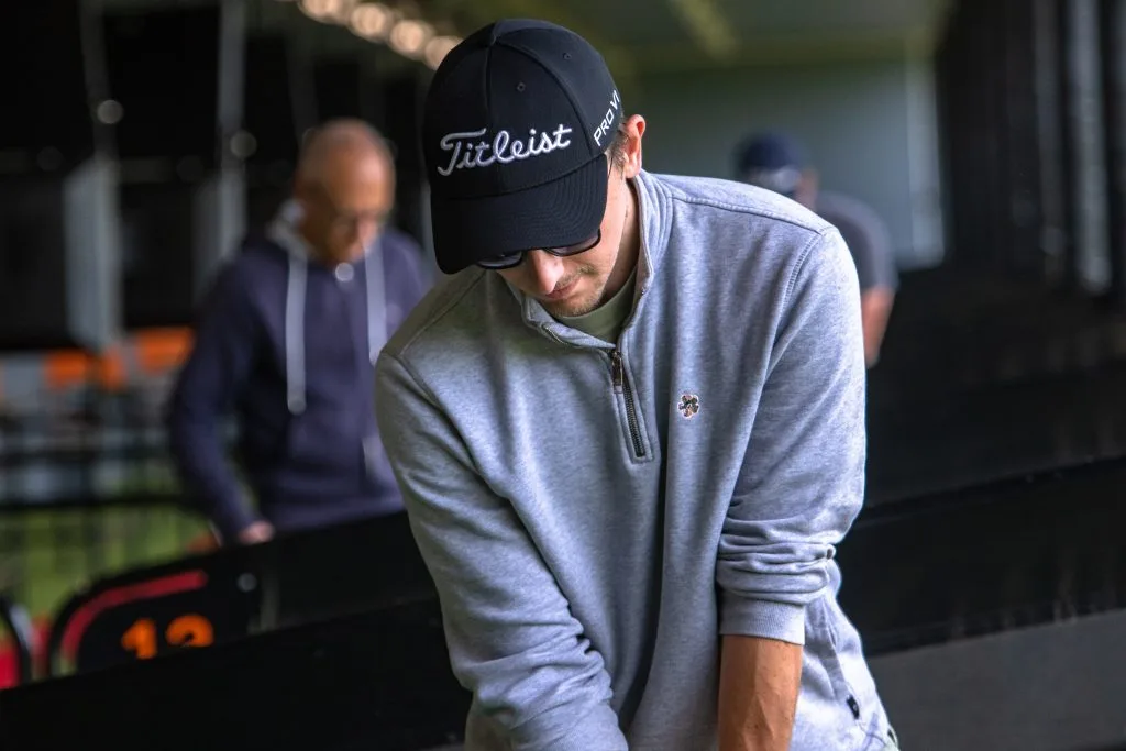 Golfer preparing to hit a golf ball on a trackman driving range in surrey