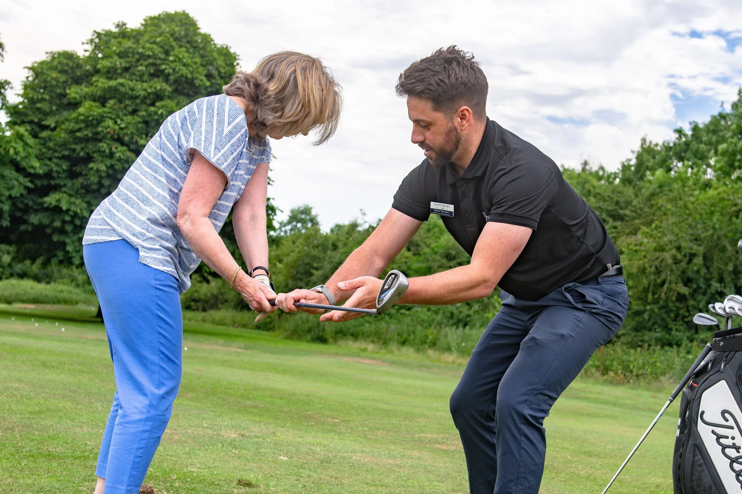 man teaching a women the key to a good golf swing at a golf lesson in woking