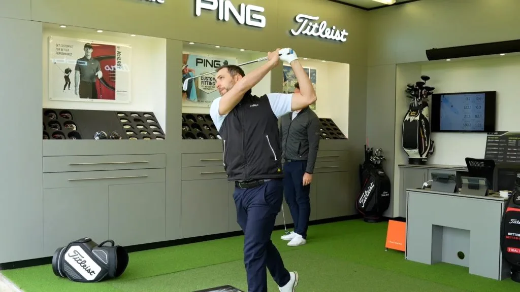 golfer trying new golf clubs at a modern professional golf fitting session in woking